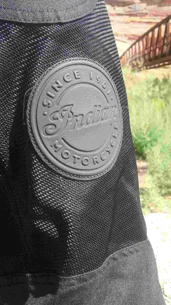 Displayed prominently in the foreground is the Indian Logo, embossed on a round patch of leather. 