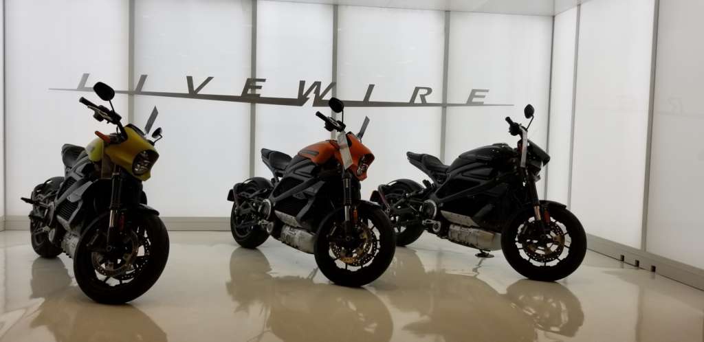 Three Harley-Davidson LiveWire's on display in a brightly lit alcove.