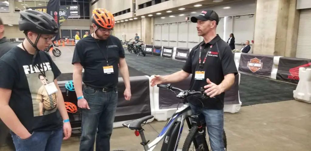 An instructor gives Staff Writer Eric Leaverton and son instruction on how to operate a Yamaha electric bicycle. 