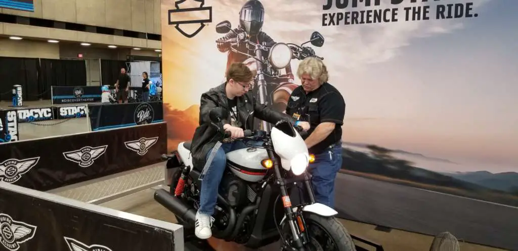 Our son sits on the Harley-Davidson StreetRod 750 while the handler instructs him in shifting techniques.