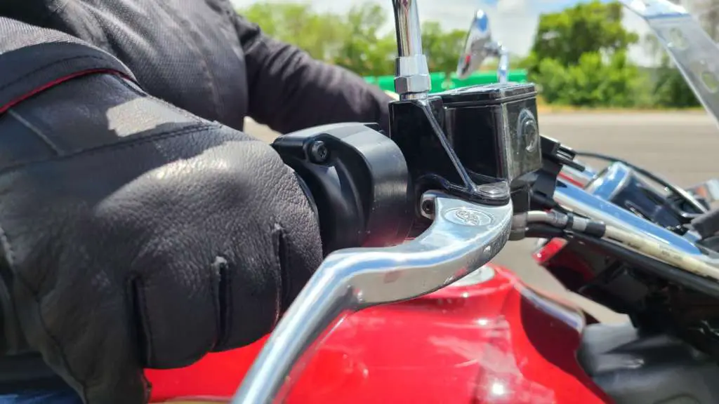 An Indian Summer Ep7 - Luxurious Leather Close-up of a woman gripping a motorcycle throttle, wearing black leather Classic Riding Gloves by Indian Motorcycle.