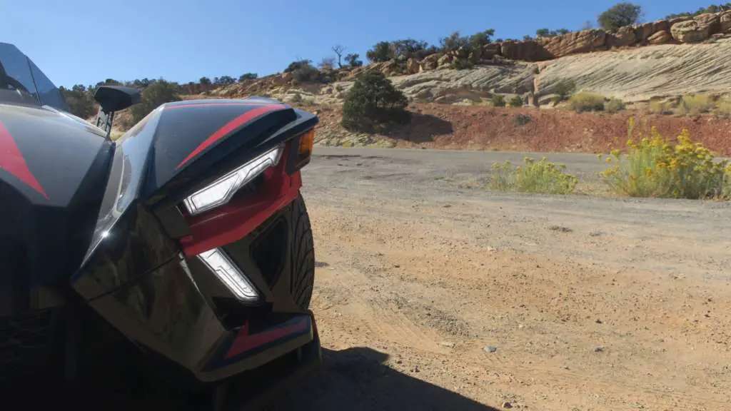 From TMW's Slingshot R review, a close-in angle of the Slingshots aggressive front end. Highlighted is the bright LED accent lights and rugged Utah scenery.