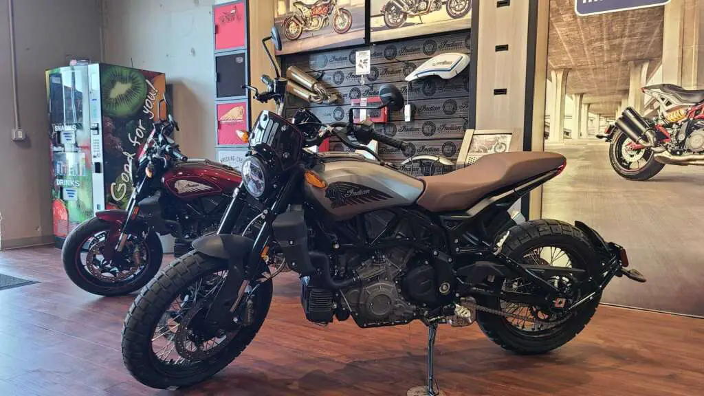 Other trim levels of the Indian FTR pictured the the showroom, with a wall of accessories in the background.